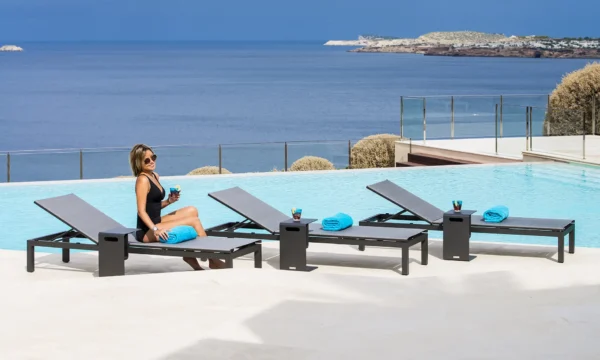 Cadzand napozóágyak a tengerparti teraszon, ahol egy napozó hölgy koktélt iszik